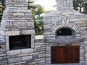 Forno Bravo fireplace kit next to a wood fired oven
