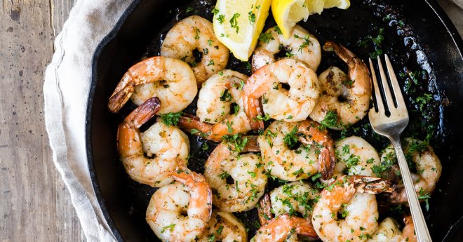 Cooked Shrimp in a Cast Iron Pan with Basil, Lemons and a Glass of White Wine