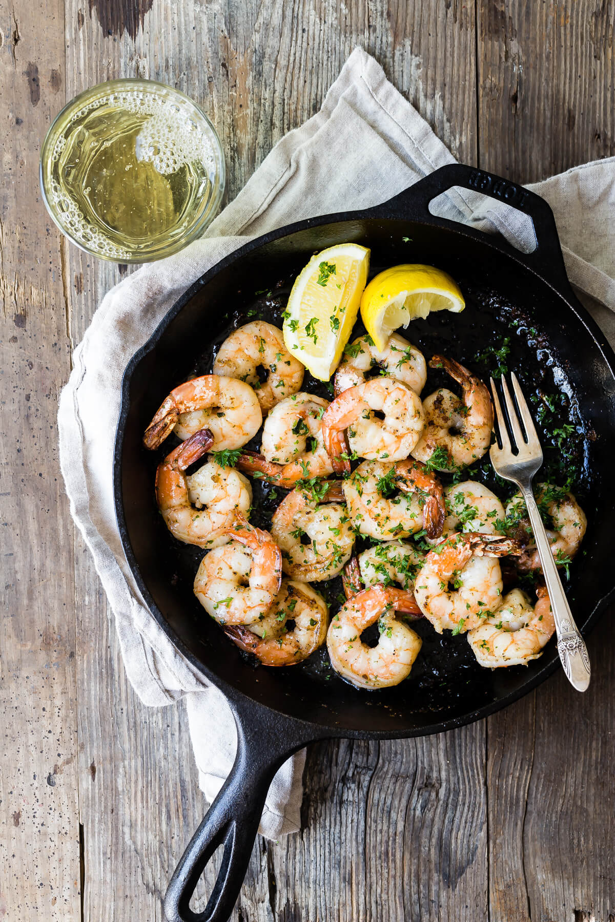 Cooked Shrimp in a Cast Iron Pan with Basil, Lemons and a Glass of White Wine