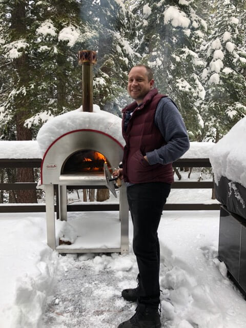 Man in front of a Bella Medio28 Wood Burning Oven In a Foot of Snow