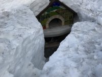 Pompeii Pizza Oven buried in deep snow with a steps dug to it