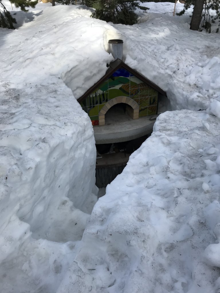 Pompeii Pizza Oven buried in deep snow with a steps dug to it