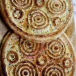2 baked Eid Bread rounds coated in Olive Oil with Circle Pattern on top