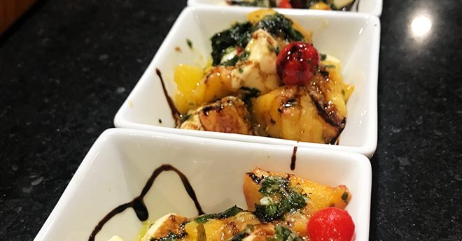 Wood Fired Peach Caprese Salad in white square bowls