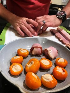 Plate with stuffed peppers partially wrapped in ham slices