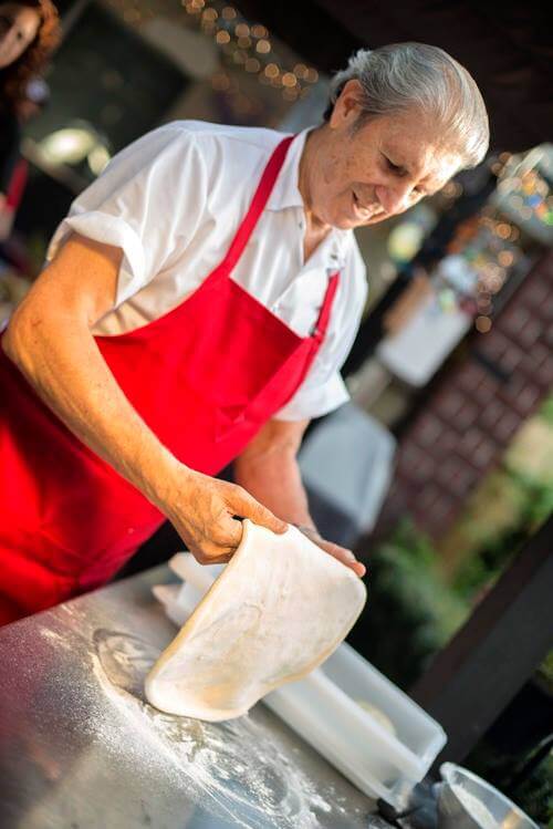 man stretching pizza dough