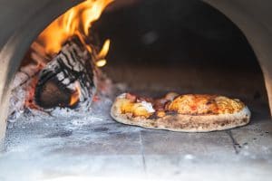 pizza baking in wood fired oven