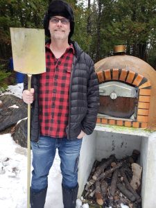 Male with Pizza Peel adn Wood Fired Oven in Snow