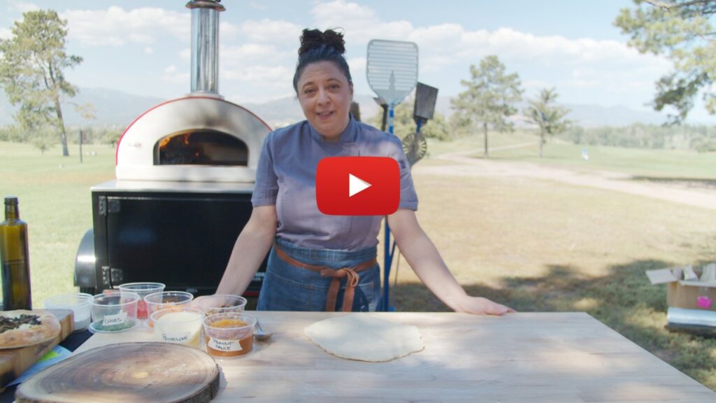 Female chef in front of Bella Pizza Oven