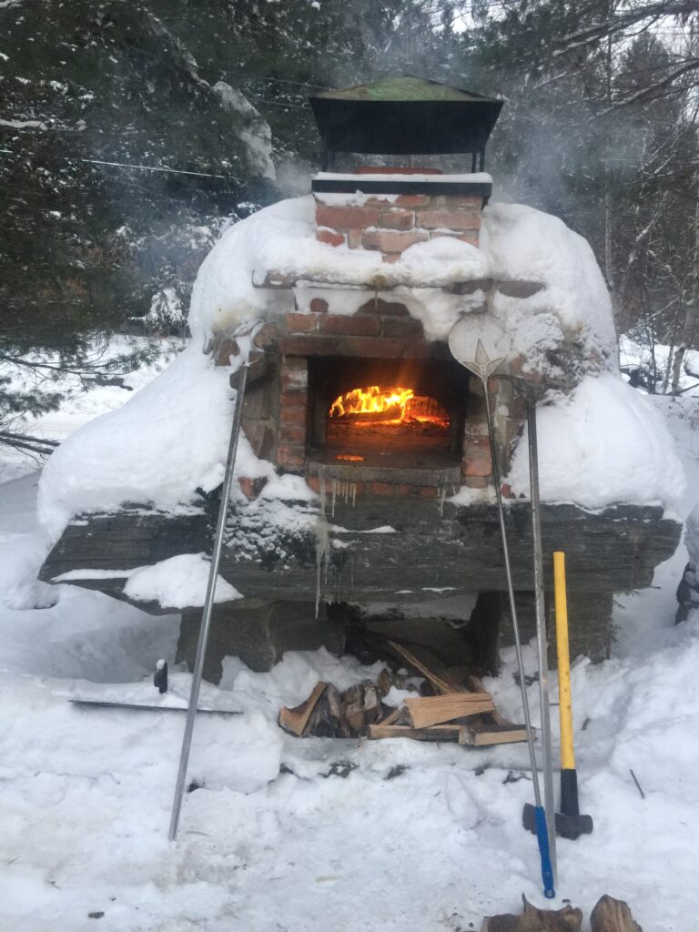 rock oven in snow with fire